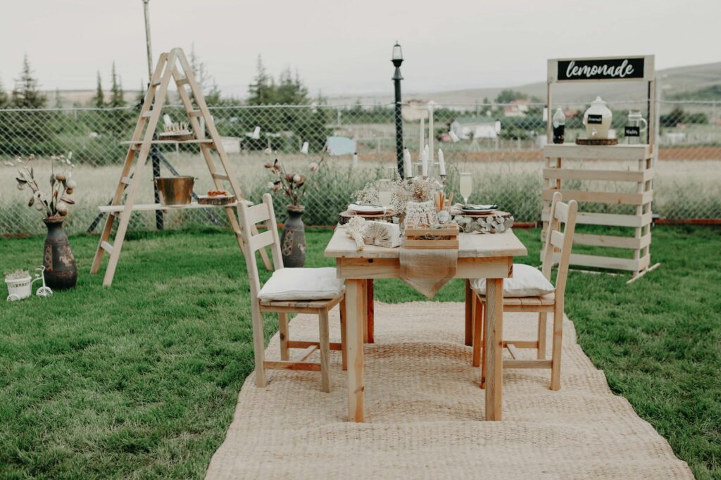 Elegant outdoor wooden dining setup with lemonade stand, perfect for events.