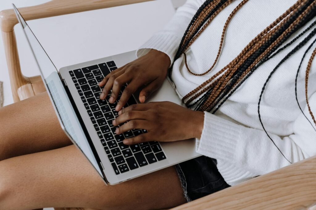 Person typing on a laptop indoors, showcasing modern technology and lifestyle.