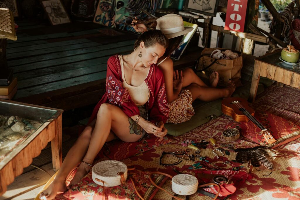 Two women enjoying a laid-back moment in a bohemian-style indoor market, surrounded by assorted merchandise.