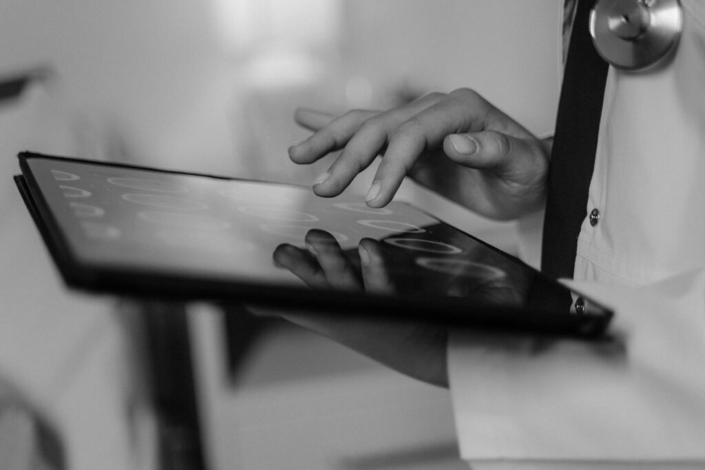 Close-up of a doctor's hand using a touchscreen tablet, highlighting digital healthcare technology.